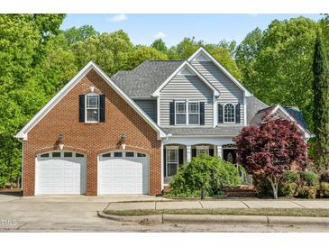 Charming two-story home with a brick and vinyl exterior, two-car garage, and manicured landscaping at 249 Mill Creek Dr, Clayton, NC 27527