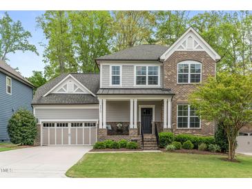 Charming two-story home featuring a brick facade, covered porch, well-maintained landscaping and an attached two car garage at 2812 Lemnos Dr, Apex, NC 27502
