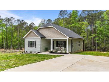 Charming single-story home with a well-manicured lawn, cozy front porch and extended driveway at 318 Natchez Trace, Fuquay Varina, NC 27526