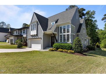 Stunning exterior of a two-story home with large windows, manicured lawn, and charming curb appeal at 3416 Edgemont Dr, Raleigh, NC 27612