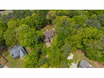 An aerial view of a quaint home nestled within lush, mature trees at 3428 Hardwood Dr, Apex, NC 27539