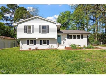 Charming two-story home with a freshly cut lawn and a mix of trees and sunlight at 3713 Arrowwood Dr, Raleigh, NC 27604