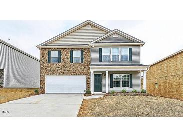 Two-story home featuring brick and vinyl siding, a manicured lawn, and an attached two-car garage at 487 Lochalsh Dr, Gibsonville, NC 27249