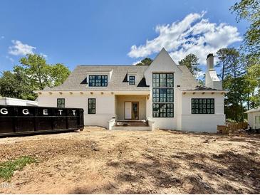 Stunning new construction shows a white brick home with black framed windows and a chimney at 5504 Kingwood Dr, Raleigh, NC 27609