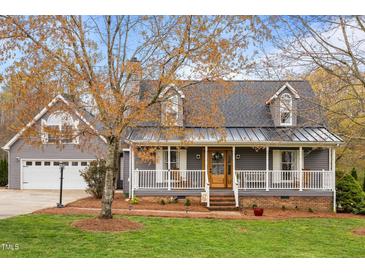 Charming home featuring a covered front porch, gray siding and dormer windows at 555 Canterwood Dr, Mebane, NC 27302
