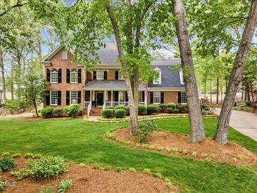 Charming brick home with manicured lawn, lush landscaping and a welcoming front porch at 7709 Oakmont Pl, Raleigh, NC 27615