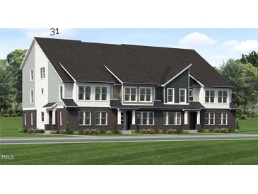 New townhome exterior showcasing brick and siding with a well-manicured lawn at 811 Fireship Rd, Fuquay Varina, NC 27526