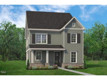 Charming two-story home with a traditional design, landscaped yard, and covered entry at 813 Fireship Rd, Fuquay Varina, NC 27526