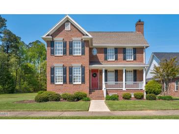 Charming two-story brick home with a red front door and a welcoming front porch and manicured front lawn at 88 Eltham, Rocky Mount, NC 27804