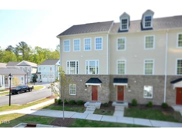 Beautiful three-story townhome featuring a brick and siding exterior with large windows at 1020 Kentlands Dr, Durham, NC 27713