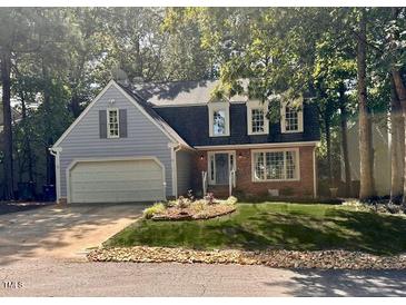 Charming two-story home featuring a blend of siding and brick, a well-manicured lawn, and a two-car garage at 1308 Bridgeport Dr, Raleigh, NC 27615