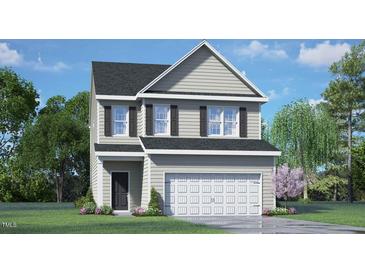 Charming two-story home featuring gray siding, a black shingled roof and well-manicured landscaping at 144 Global Ave, Fuquay Varina, NC 27526