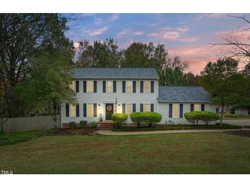 Charming two-story home featuring classic shutters, a well-manicured lawn, and lush landscaping at 2256 W Front St, Burlington, NC 27215