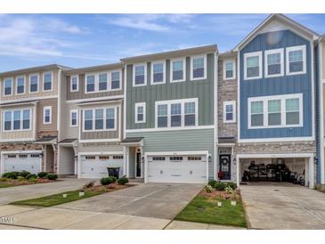 Charming townhomes feature varied color schemes, attached garages, and manicured front lawns with lush landscaping at 2313 Bay Minette Sta # 543, Apex, NC 27502