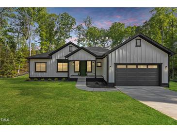 Charming single-Gathering home boasts a modern farmhouse style, complemented by a well-manicured lawn and beautiful twilight at 251 Sequoia Dr, Louisburg, NC 27549
