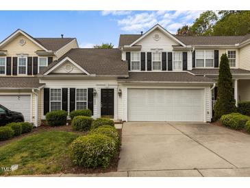 Charming townhouse with a two-car garage, landscaped yard, and classic black shutters and accents at 292 Joshua Glen Ln, Cary, NC 27519