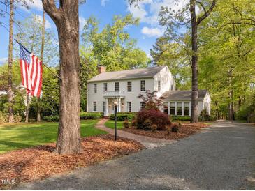 Charming two-story home with a brick walkway, mature trees, and an American flag in a well-manicured front yard at 3612 Darwin Rd, Durham, NC 27707
