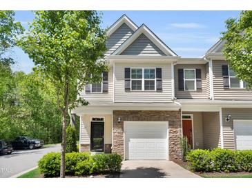 Inviting two-story townhouse with stone accents, attached garage, tidy landscaping, and charming curb appeal at 3667 Durwood Ln, Raleigh, NC 27604