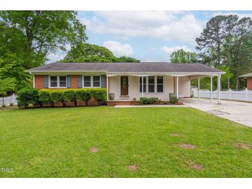 Charming single-story home featuring a well-manicured lawn, covered carport, and classic brick and siding facade at 3913 Vesta Dr, Raleigh, NC 27603