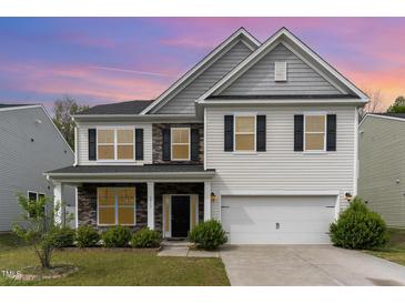 Two-story home featuring stone accents, gray and white siding and shutters, and a two-car garage at 3917 White Kestrel Dr, Raleigh, NC 27616