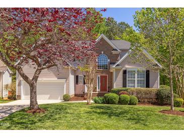 Charming two-story home with a well-manicured lawn, a brick facade, and lush landscaping at 413 Palafox Dr, Chapel Hill, NC 27516