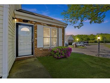 Inviting front entrance with brick and well maintained lawn and mature landscaping at 42 Riverwalk Ter, Durham, NC 27704