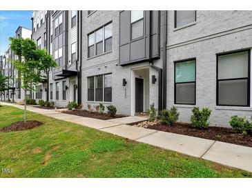 Modern townhome with gray brick, black window frames, and manicured landscaping at 433 Wait Ave # 100, Wake Forest, NC 27587