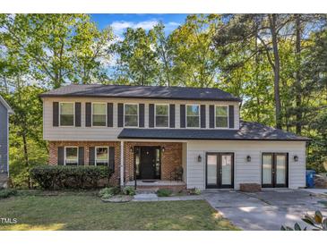 Charming two-story home featuring a brick and siding exterior, complemented by a well-manicured front yard and mature trees at 5315 Oakbrook Dr, Durham, NC 27713