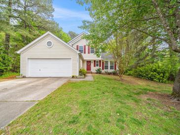 Charming two-story home with a two-car garage, red shutters, a well-maintained lawn, and mature trees at 5504 Cumberland Plain Dr, Raleigh, NC 27616