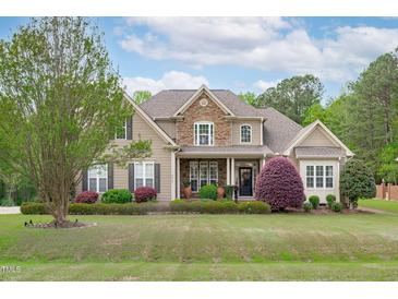 Inviting two-story home features a mix of stone and siding with a beautifully landscaped front yard at 6512 Southern Times Dr, Raleigh, NC 27603