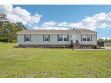 Charming single-story home with a well-manicured lawn and inviting front porch at 7228 Lowery Meadow Dr, Wendell, NC 27591