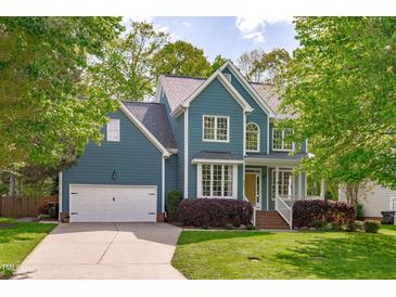 Charming two-story home with a well-manicured lawn, blue siding, and an attached two-car garage at 8005 Somerdale Dr, Durham, NC 27713