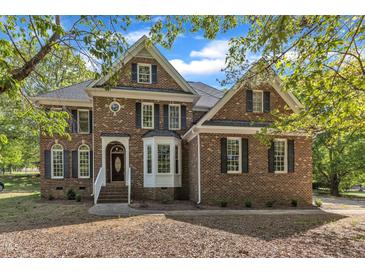 Elegant brick home with a manicured lawn and classic architectural details at 8022 Hogan Dr, Wake Forest, NC 27587