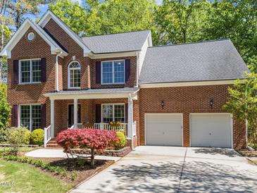 Charming two-story brick home with an attached two-car garage and well-manicured landscaping at 8212 Duck Creek Dr, Raleigh, NC 27616