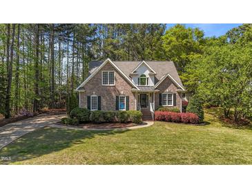 Charming brick home featuring manicured landscaping and mature trees in a desirable neighborhood at 903 Oldwyck Dr, Fuquay Varina, NC 27526