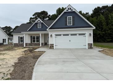 Charming two-story home with a spacious two car garage and a well-manicured lawn and inviting front porch at 1000 Peedin Rd, Selma, NC 27576