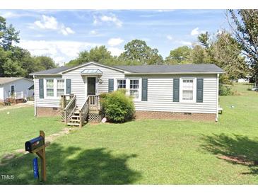 Charming single-story home with a well-maintained lawn and inviting front entrance at 125 S State St, Haw River, NC 27258