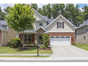Charming two-story home with a manicured lawn, brick accents, and an attached two-car garage at 126 Elmsford St, Durham, NC 27703