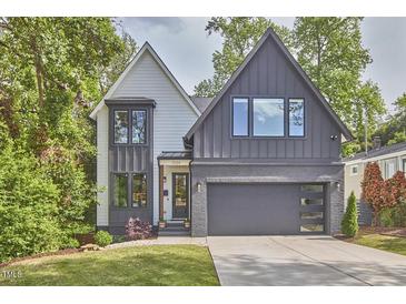 Charming two-story home featuring a modern gray and white exterior, well-manicured lawn, and attached garage at 1336 Courtland Dr, Raleigh, NC 27604