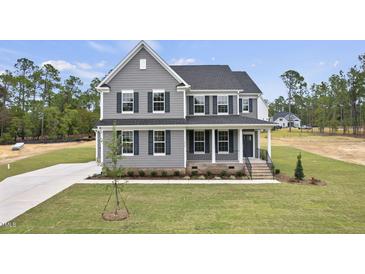 Charming two-story home with gray siding, black shutters, and inviting front porch, landscaped with a well-maintained lawn at 134 Ivy Ridge Rd, Chapel Hill, NC 27516