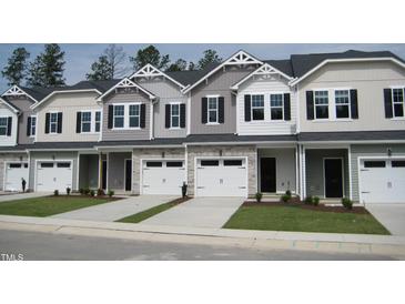 Charming townhomes boast manicured lawns, inviting garages, and stylish architectural details at 143 Rolesville Ridge Dr, Rolesville, NC 27571