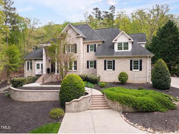 Elegant brick home boasts manicured landscaping and a welcoming front entrance at 16106 Morehead, Chapel Hill, NC 27517