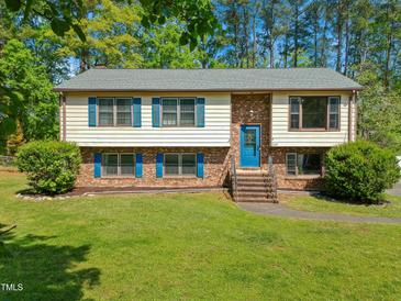 Charming two-story home with blue shutters and brick accents, set on a lush green lawn at 1624 Cone Ave, Apex, NC 27502