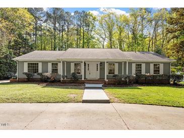 Charming single-story home boasts a well-maintained lawn, mature trees, and inviting front porch at 2225 Whitley Dr, Durham, NC 27707