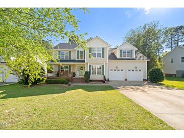Charming two-story home featuring a landscaped yard, front porch, and two-car garage at 226 Marquis Dr, Cameron, NC 28326