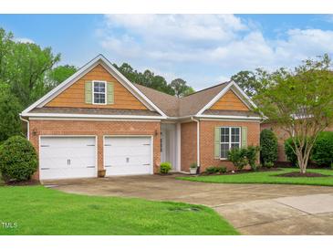 Charming brick home with well-manicured lawn, two-car garage, and eye-catching green shutters at 4 Calwell Creek Dr, Chapel Hill, NC 27517