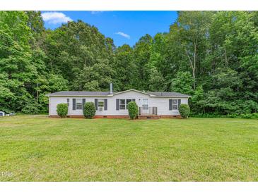 Charming single-story home with a well-manicured lawn and mature trees at 4047 Mistletoe Dr, Burlington, NC 27217