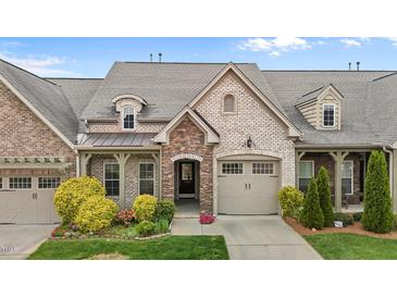 Charming home exterior featuring stone and brick accents, a two-car garage, and professionally landscaped front yard at 4105 Gilchrist Dr, Burlington, NC 27215