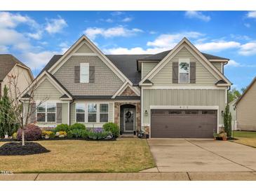 Charming two-story home featuring a two-car garage, stone accents, and professionally landscaped front yard at 412 Airedale Trl, Garner, NC 27529