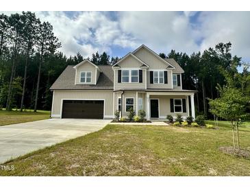 Charming two-story home featuring a two-car garage, well-manicured lawn, and classic design elements at 437 Earnest Way, Kenly, NC 27542